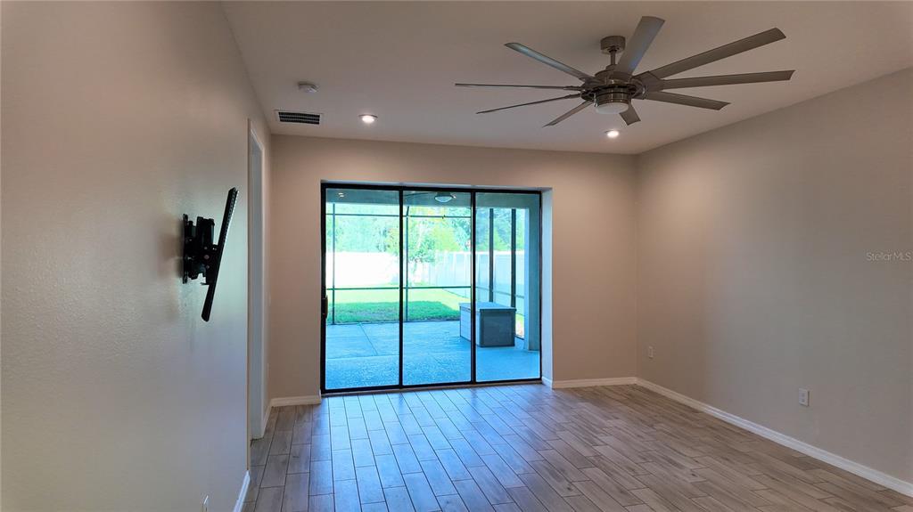 A living room with tile flooring, a ceiling fan, and sliding glass doors to a patio — 1287 VERDANT GLADE PLACE, WINTER PARK, FL