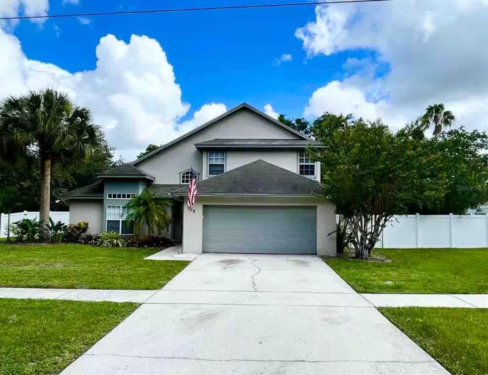 A two-story suburban house with a gray exterior, a two-car garage, and a concrete driveway — 102 W FREDERICK AVENUE, LAKE MARY, FL