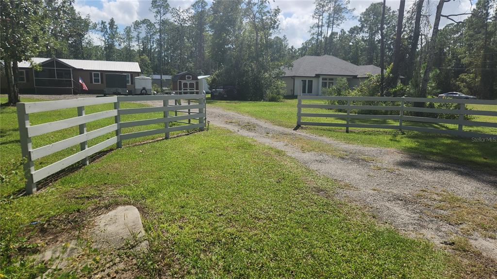 A single-story manufactured home with a screened front porch and a metal roof — 5171 MAHOGANY BOULEVARD, BUNNELL, FL