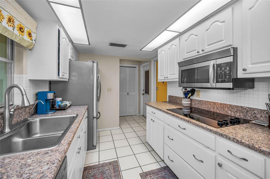 A single-story house with a stone facade, brown trim, and a two-car garage — 1368 WILLIAMS DRIVE, CLEARWATER, FL