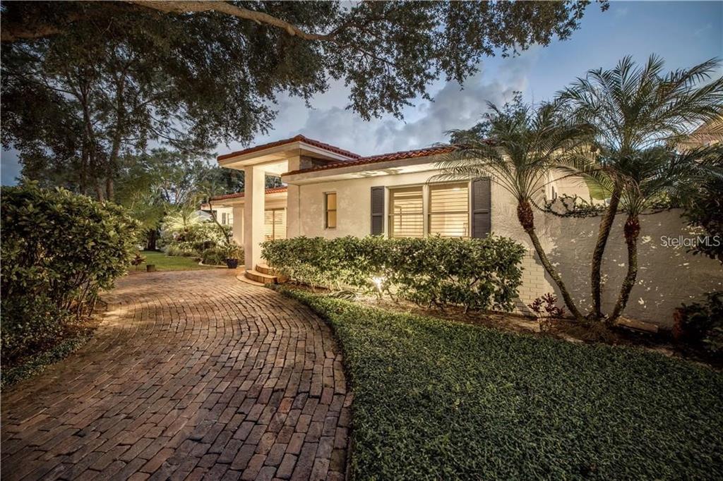 A single-story house with a brick driveway, white stucco walls, and a tiled roof — 2200 2ND STREET N, ST PETERSBURG, FL