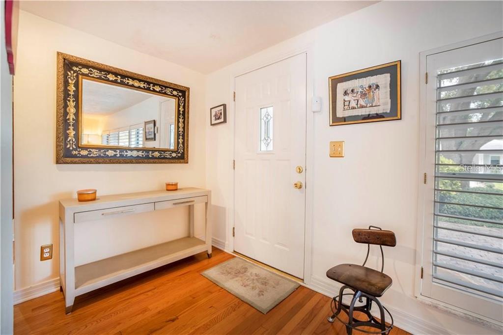 An entryway features hardwood floors, a white console table, a mirror, and a front door — 2200 2ND STREET N, ST PETERSBURG, FL