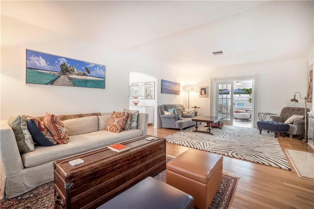 A living room features a large beige sofa, a wooden trunk coffee table, and hardwood floors — 2200 2ND STREET N, ST PETERSBURG, FL