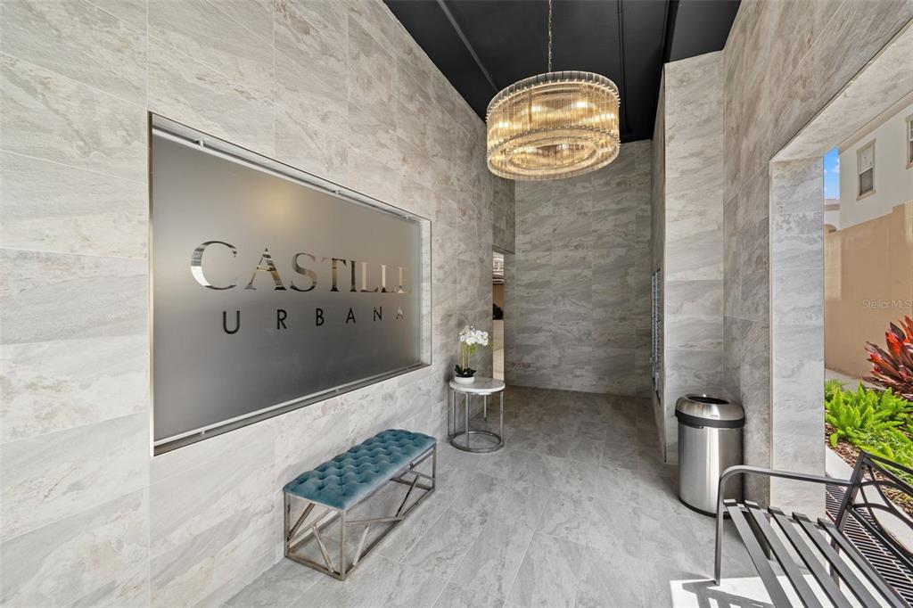 The exterior entrance of a modern apartment building features a sign reading Castille Urbana — 600 3RD AVENUE S UNIT 207, ST PETERSBURG, FL