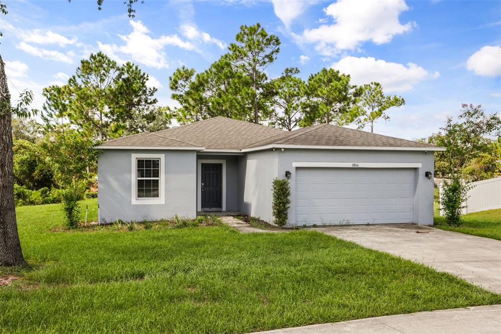 A single-story gray house with a two-car garage and a front lawn under a sky — 2860 SURF DRIVE, DELTONA, FL