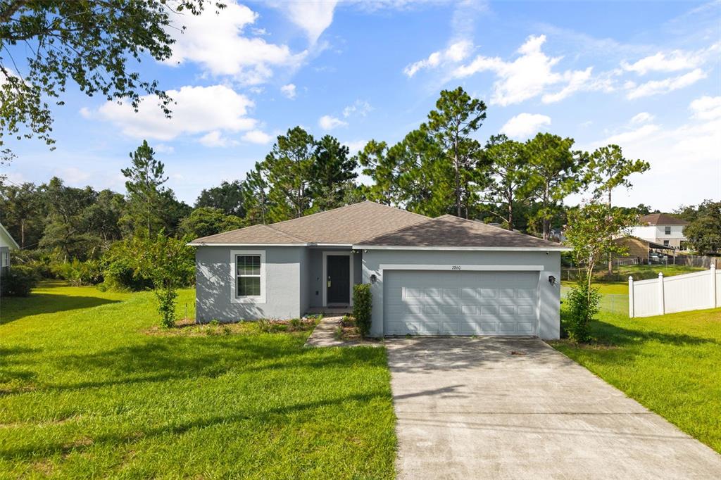 A single-story gray house with a two-car garage and a concrete driveway — 2860 SURF DRIVE, DELTONA, FL