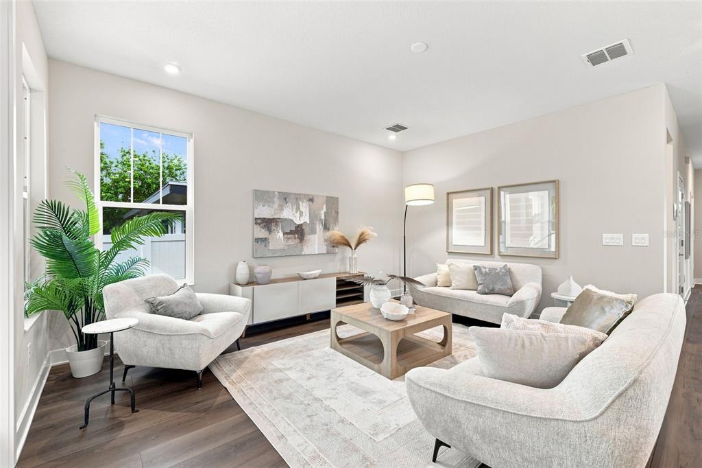 A living room features light-colored furniture, a wooden coffee table, and a large potted plant — 5633 DARTMOUTH AVENUE N, ST PETERSBURG, FL