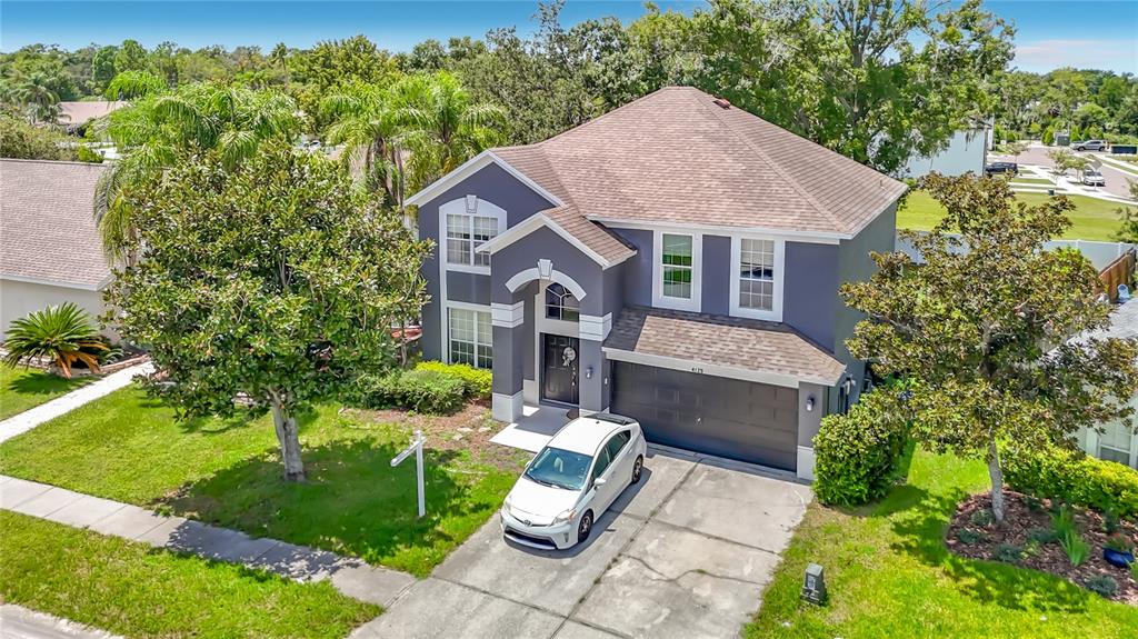 An aerial view of a two-story gray house with a brown roof and a driveway — 4129 TARKINGTON DRIVE, LAND O LAKES, FL