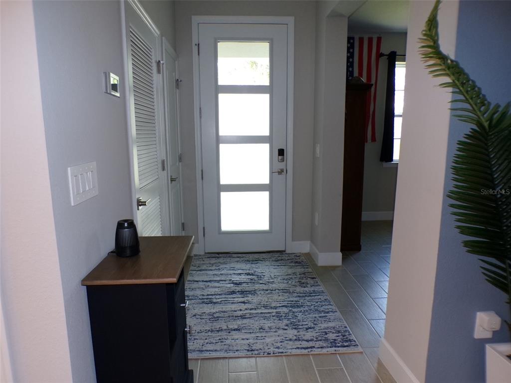 An entryway features a white front door with glass panels, tile flooring, and a rug — 2871 ARMENIA ROAD, NORTH PORT, FL