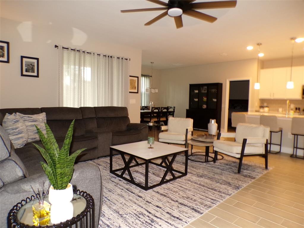A living room features a grey sectional sofa, white armchairs, and a modern coffee table — 2871 ARMENIA ROAD, NORTH PORT, FL