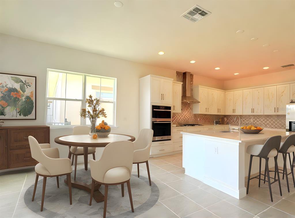 A bright kitchen and dining area with white cabinetry, a center island, and modern furniture — 5019 DANCY LANE, ST CLOUD, FL