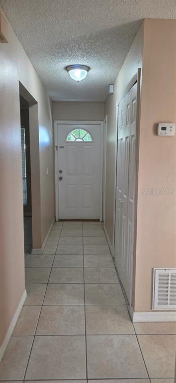 A tiled hallway leads to a white front door with a small arched window — 3302 ROYAL STREET, WINTER PARK, FL