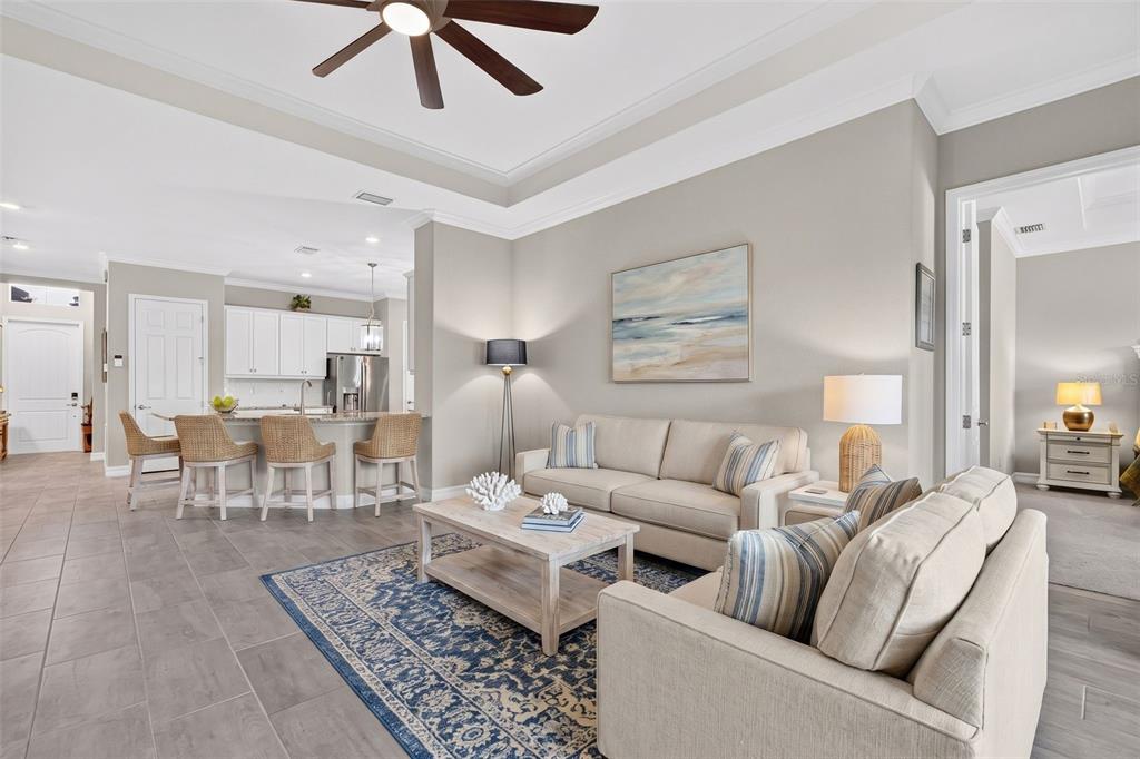A bathroom features a granite vanity, white cabinets, a toilet with storage, and a tiled shower — 11825 PERENNIAL PLACE, BRADENTON, FL