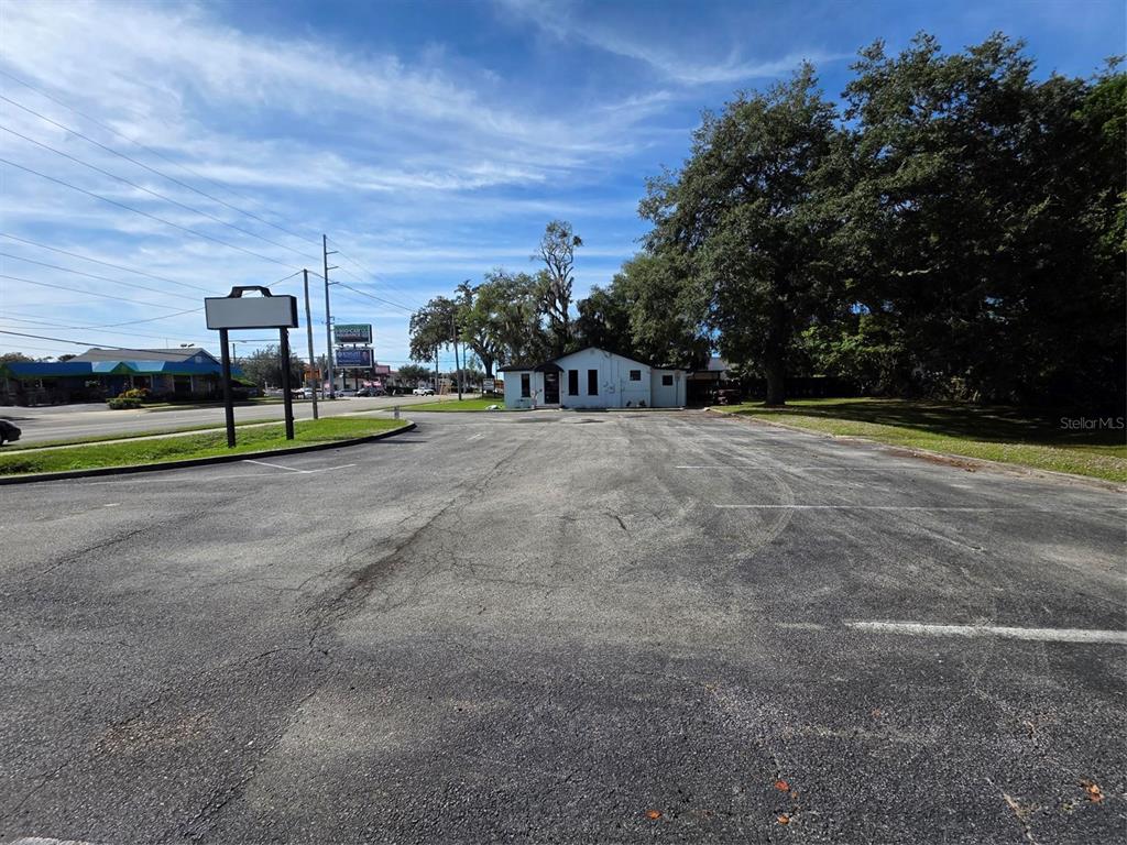 A paved parking lot leads to a small, single-story building surrounded by trees — 217 E STATE ROAD 434, LONGWOOD, FL