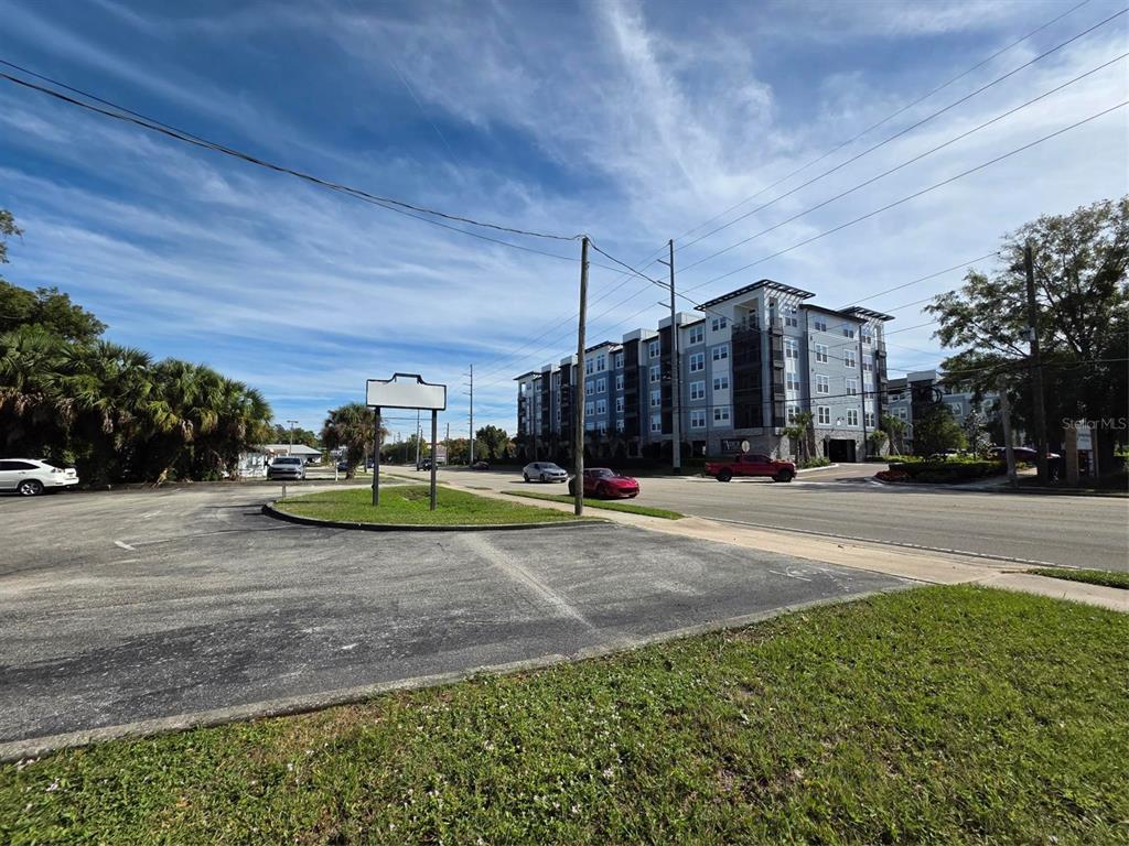 A view of a paved parking area, a street, and a modern multi-story apartment building — 217 E STATE ROAD 434, LONGWOOD, FL