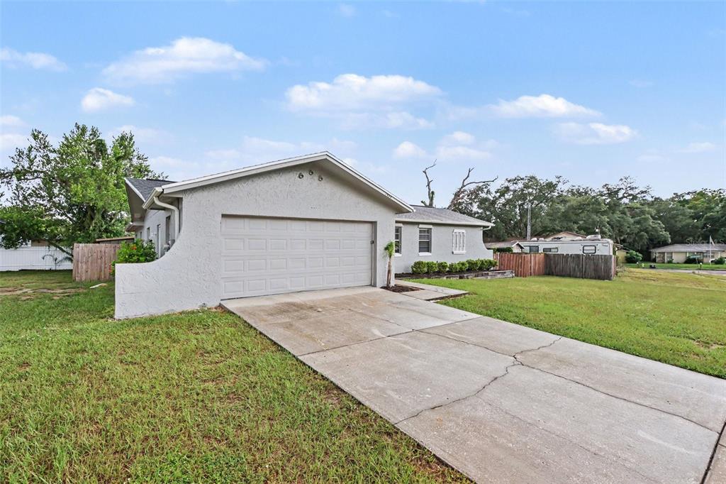 A single-story house with a gray stucco exterior, a two-car garage, and a concrete driveway — 1909 SHANNONWOOD COURT, BRANDON, FL