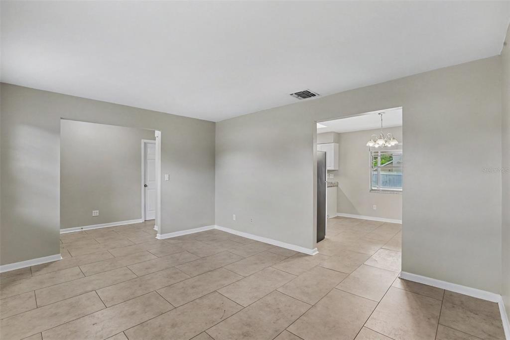 An interior view shows a tiled living area with neutral walls and two arched doorways — 1909 SHANNONWOOD COURT, BRANDON, FL