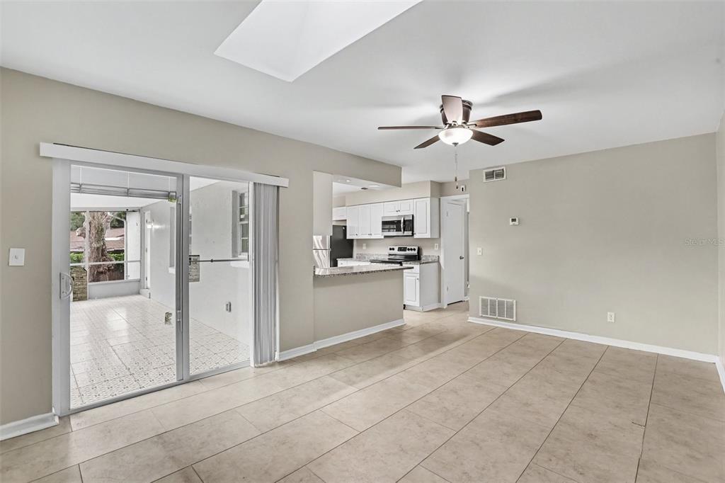A living room with tile flooring, a ceiling fan, and a sliding door to a patio — 1909 SHANNONWOOD COURT, BRANDON, FL