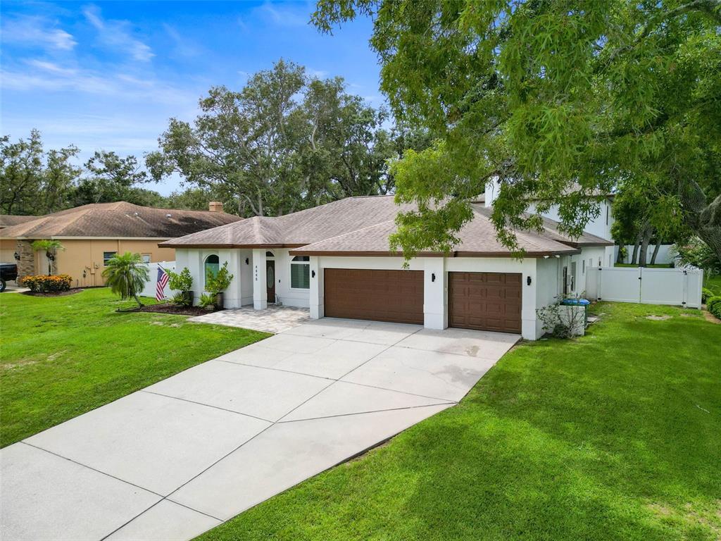 A single-story house with a two-car garage, a concrete driveway, and a large front lawn — 4448 GLENBROOK DRIVE, PALM HARBOR, FL