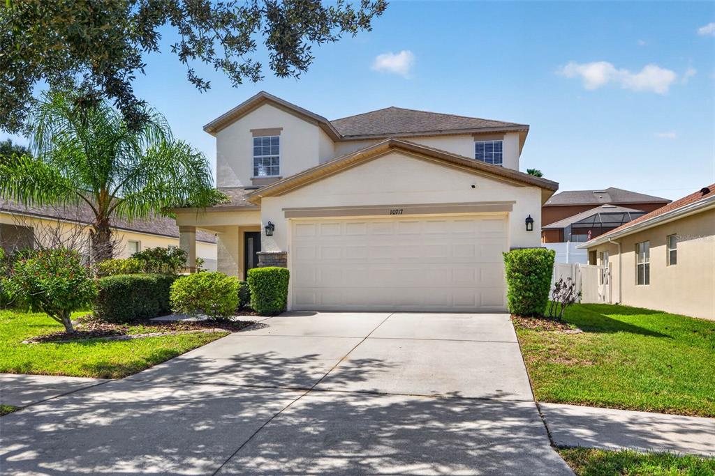 A two-story suburban house with a beige stucco exterior and a two-car garage — 10717 SHADY PRESERVE DRIVE, RIVERVIEW, FL