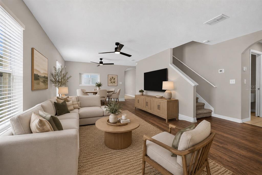 A living room with a sectional sofa, wooden coffee table, television, and staircase — 10717 SHADY PRESERVE DRIVE, RIVERVIEW, FL