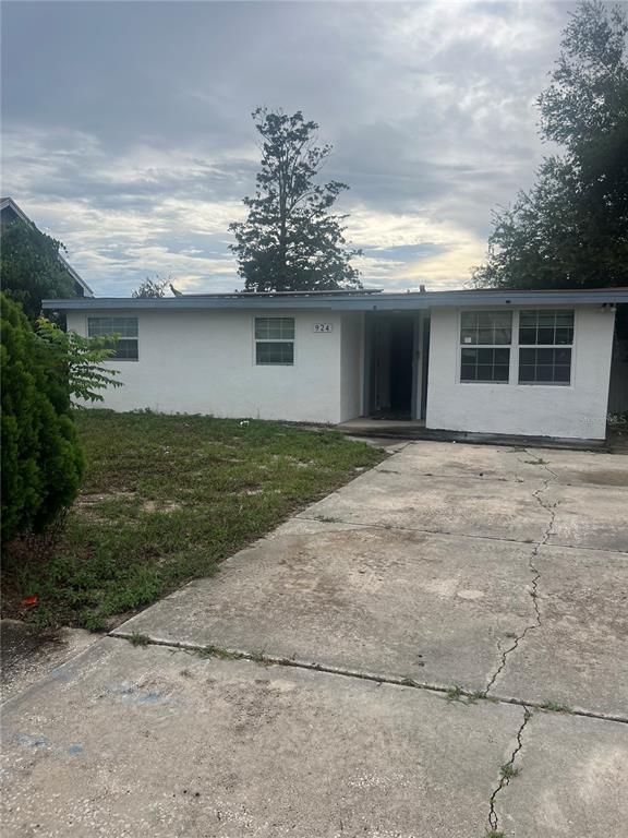 A single-story white house with a flat roof and a cracked concrete driveway — 924 FERNDELL ROAD, ORLANDO, FL