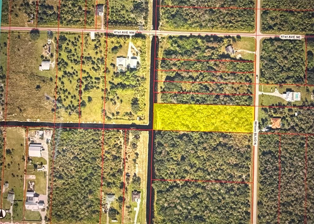 An aerial map shows a rectangular, yellow-highlighted plot of land bordered by roads and canals — 4021 WILSON BOULEVARD N, NAPLES, FL