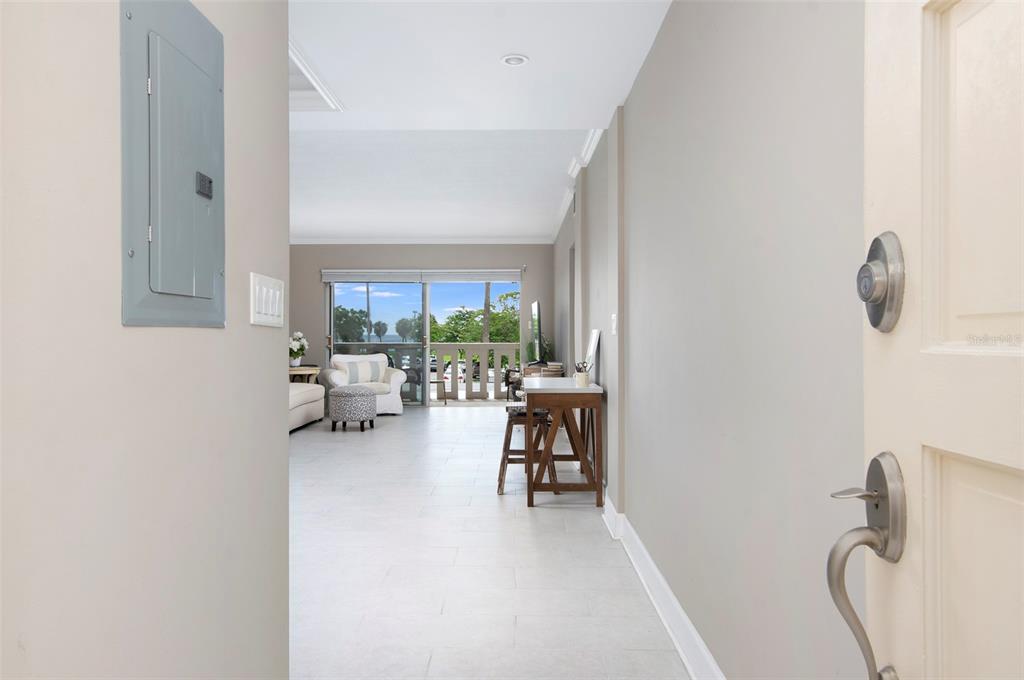 An entryway leads into a bright living area with tile floors and a balcony view — 1200 N SHORE DRIVE NE UNIT 208, ST PETERSBURG, FL