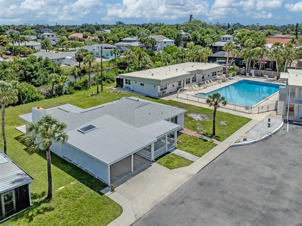 An aerial view shows a house with a carport, a swimming pool, and surrounding landscaping — 908 VILLAS DRIVE UNIT 45, VENICE, FL