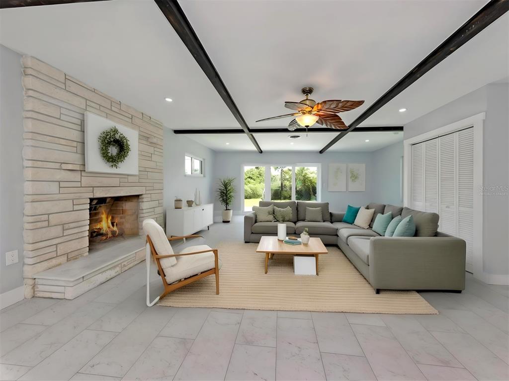 A living room features a stone fireplace, exposed ceiling beams, and a large sectional sofa — 908 VILLAS DRIVE UNIT 45, VENICE, FL