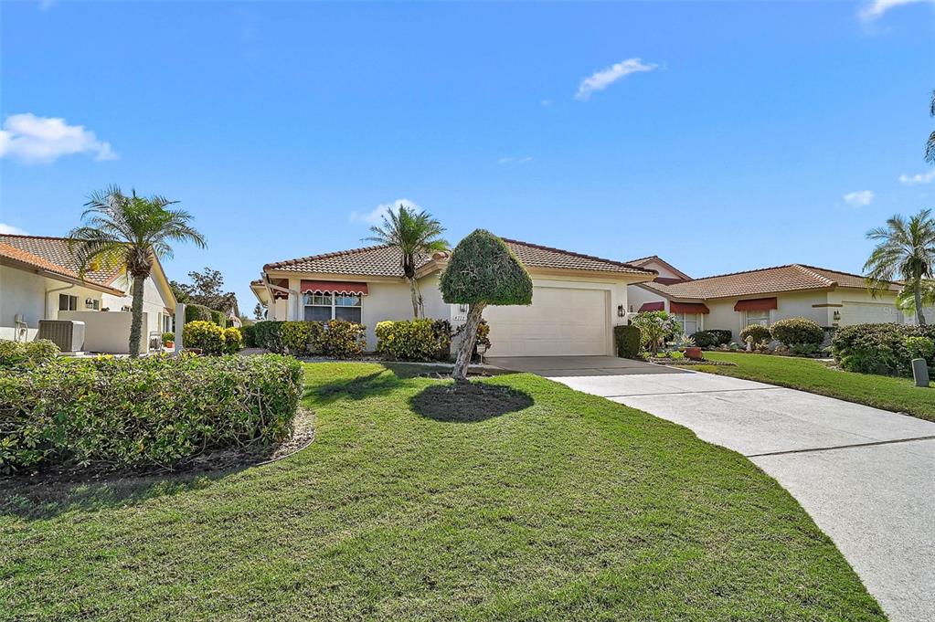 A single-story house with a two-car garage, a concrete driveway, and a manicured lawn — 4717 PERIDIA BOULEVARD E, BRADENTON, FL