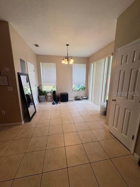 A tiled dining area features a chandelier, two windows, and a sliding glass door — 6547 BLACK MANGROVE DRIVE, LARGO, FL