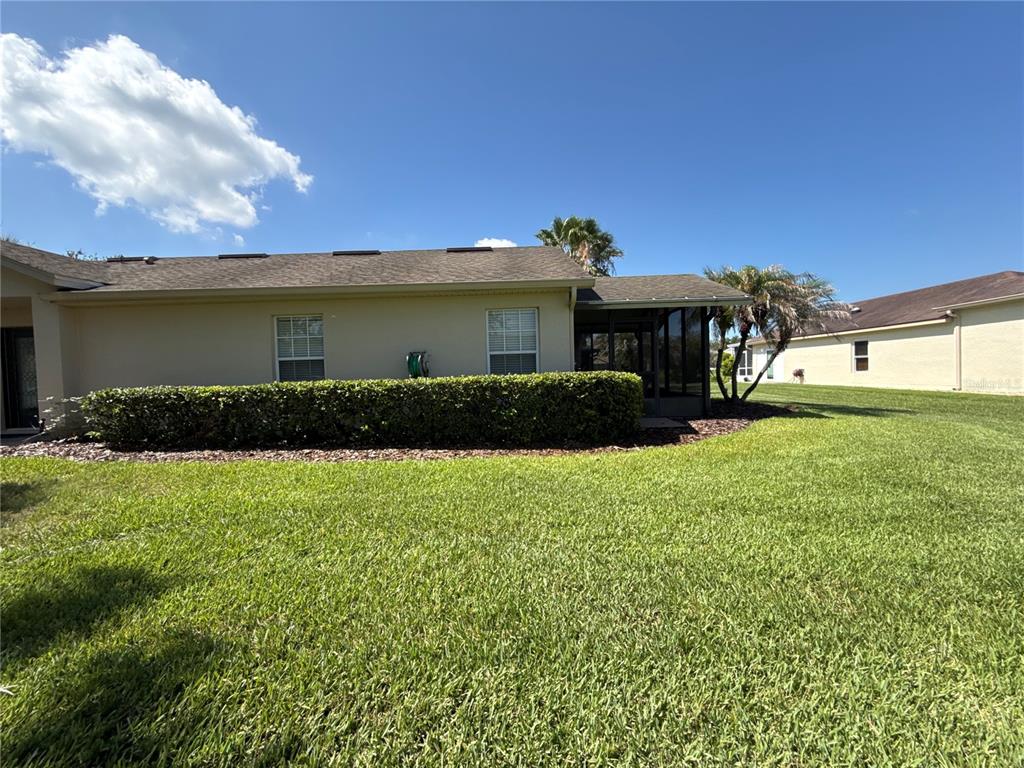 The exterior of a beige single-story house features a paved walkway and a front entrance — 674 VINEYARD WAY, POINCIANA, FL