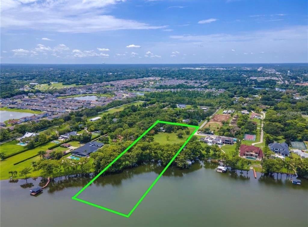 An aerial view shows a waterfront lot outlined in green with surrounding residential properties — 1133 BELLA LAGO COVE, WINTER PARK, FL