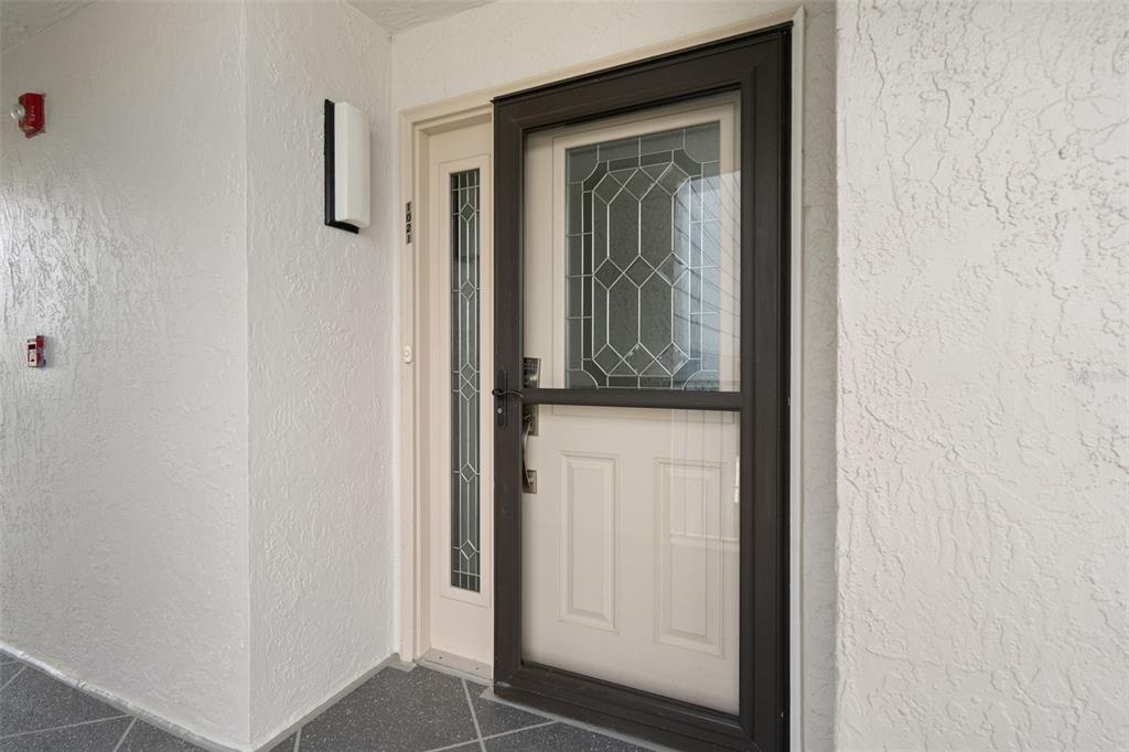 A front entrance features a white door with a side light and a dark storm door — 4650 BAY BOULEVARD UNIT 1021, PORT RICHEY, FL