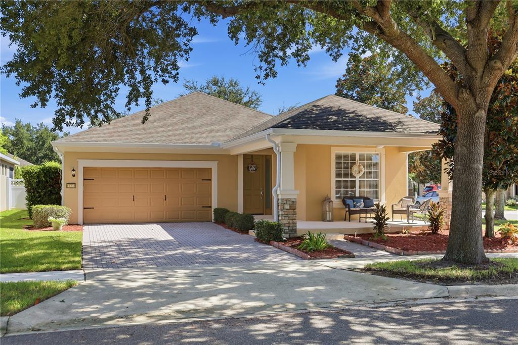 A single-story house with a tan stucco exterior, a two-car garage, and a front porch — 13231 ROXBORO ROAD, WINDERMERE, FL