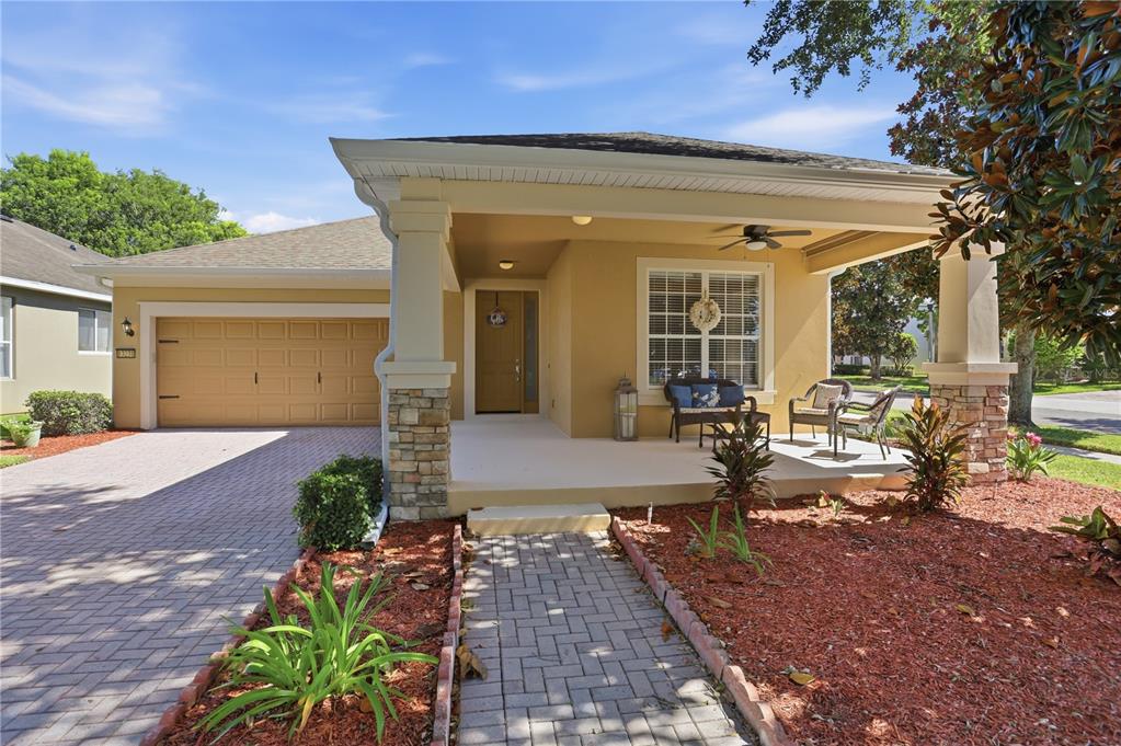 A single-story house with a tan stucco exterior, a covered front porch, and a paved driveway — 13231 ROXBORO ROAD, WINDERMERE, FL