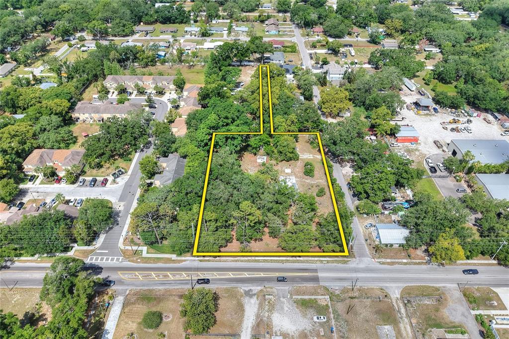 An aerial view shows a vacant, tree-covered lot outlined in yellow along a paved road — 5310 S 579 HIGHWAY, SEFFNER, FL