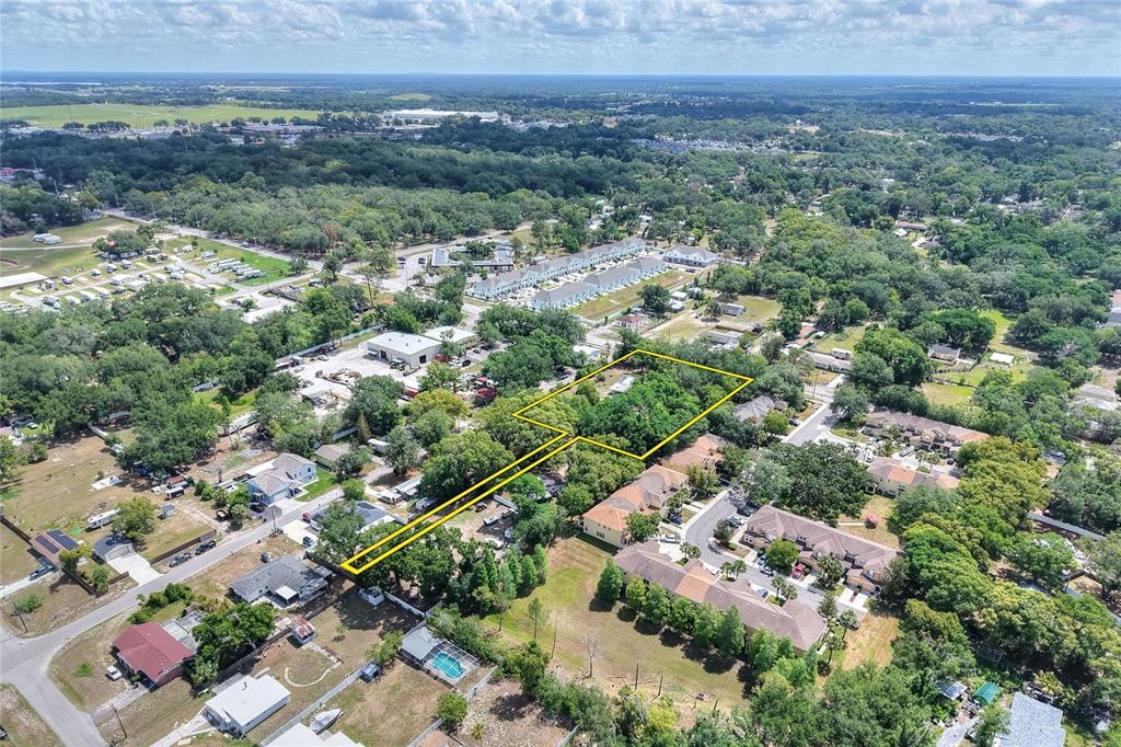 An aerial view shows a wooded lot outlined in yellow within a suburban neighborhood — 5310 S 579 HIGHWAY, SEFFNER, FL