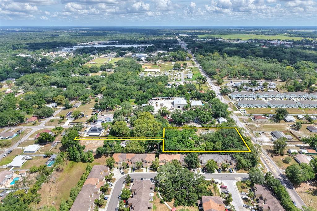 An aerial view shows a rectangular, tree-covered lot outlined in yellow near residential housing — 5310 S 579 HIGHWAY, SEFFNER, FL
