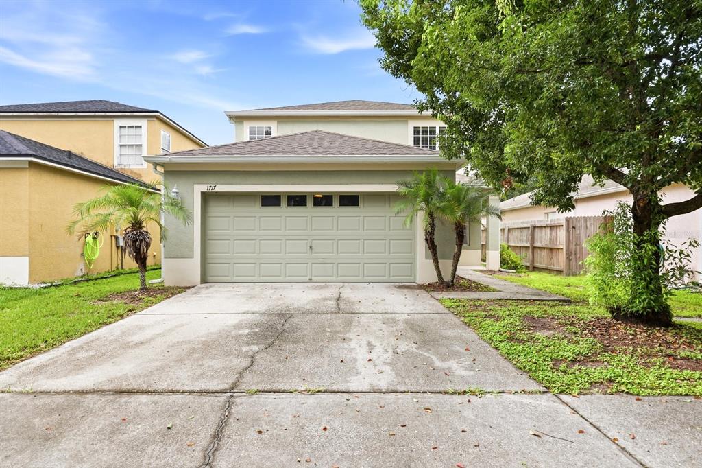 A two-story house with a green exterior, a two-car garage, and a concrete driveway — 1717 MOSAIC FOREST DRIVE, SEFFNER, FL