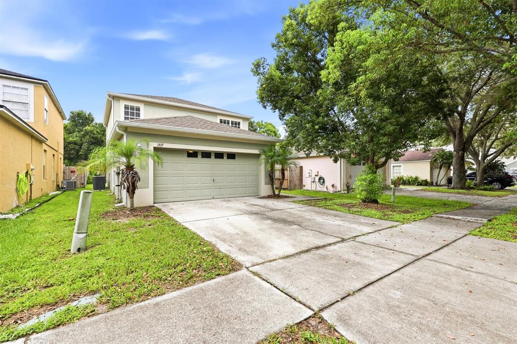 A two-story house with a light green exterior, a two-car garage, and a concrete driveway — 1717 MOSAIC FOREST DRIVE, SEFFNER, FL