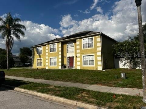 A two-story yellow house with white trim and a front door sits on a lawn — 1034 LAKE DOE BOULEVARD, APOPKA, FL