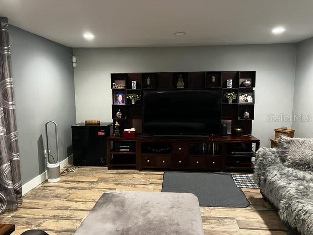 A living room features a large dark wood media center, wood-look flooring, and gray walls — 1034 LAKE DOE BOULEVARD, APOPKA, FL