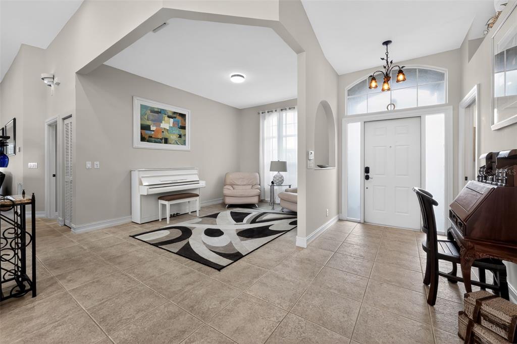 A bright foyer features tile flooring, a white piano, an area rug, and a front door — 12301 CABOT COURT, BOCA RATON, FL