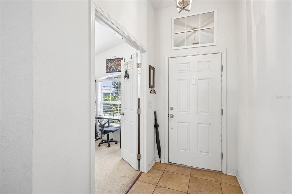 An entryway with tiled flooring, a white front door, and an open doorway to an office — 14284 FINSBURY DRIVE, SPRING HILL, FL