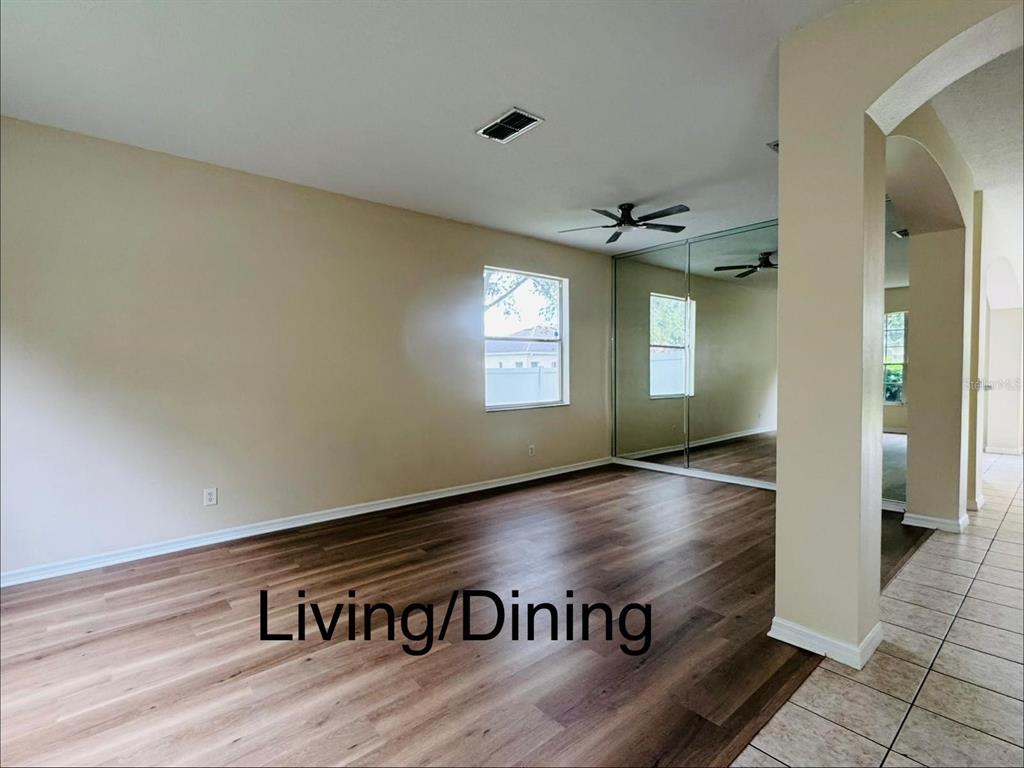 A kitchen features light gray cabinets, black countertops, stainless steel appliances, and tiled flooring — 13621 TETHERLINE TRAIL, ORLANDO, FL