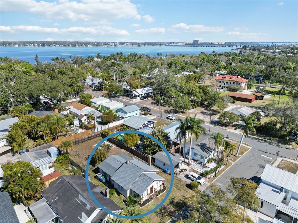 An aerial view shows a single-story house with a gray roof inside a blue circle — 2710 3RD AVENUE W, BRADENTON, FL