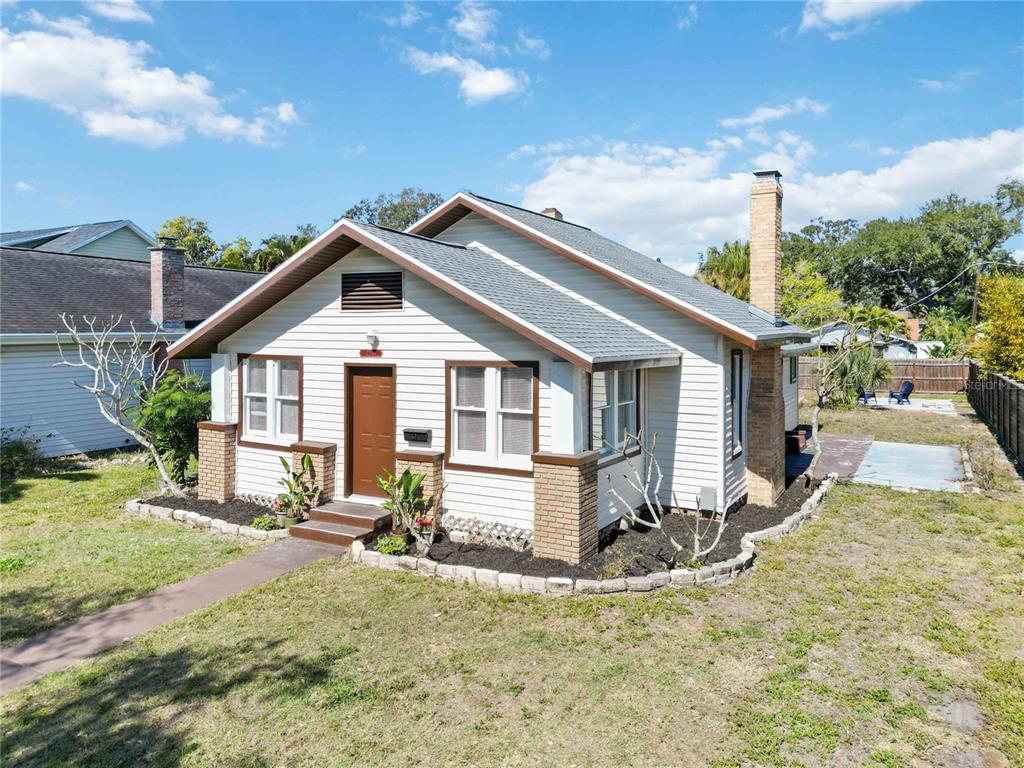 A single-story house with white siding, a brick chimney, and a small front porch — 2710 3RD AVENUE W, BRADENTON, FL