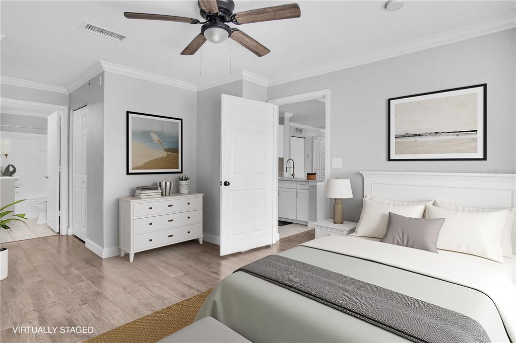 A dining area with wood-look flooring, gray walls, a pendant light, and a kitchen doorway — 18245 BRIDLE CLUB DRIVE, TAMPA, FL